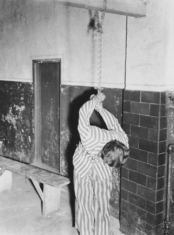 A survior reenact a torture method used on prisoners at Dachau